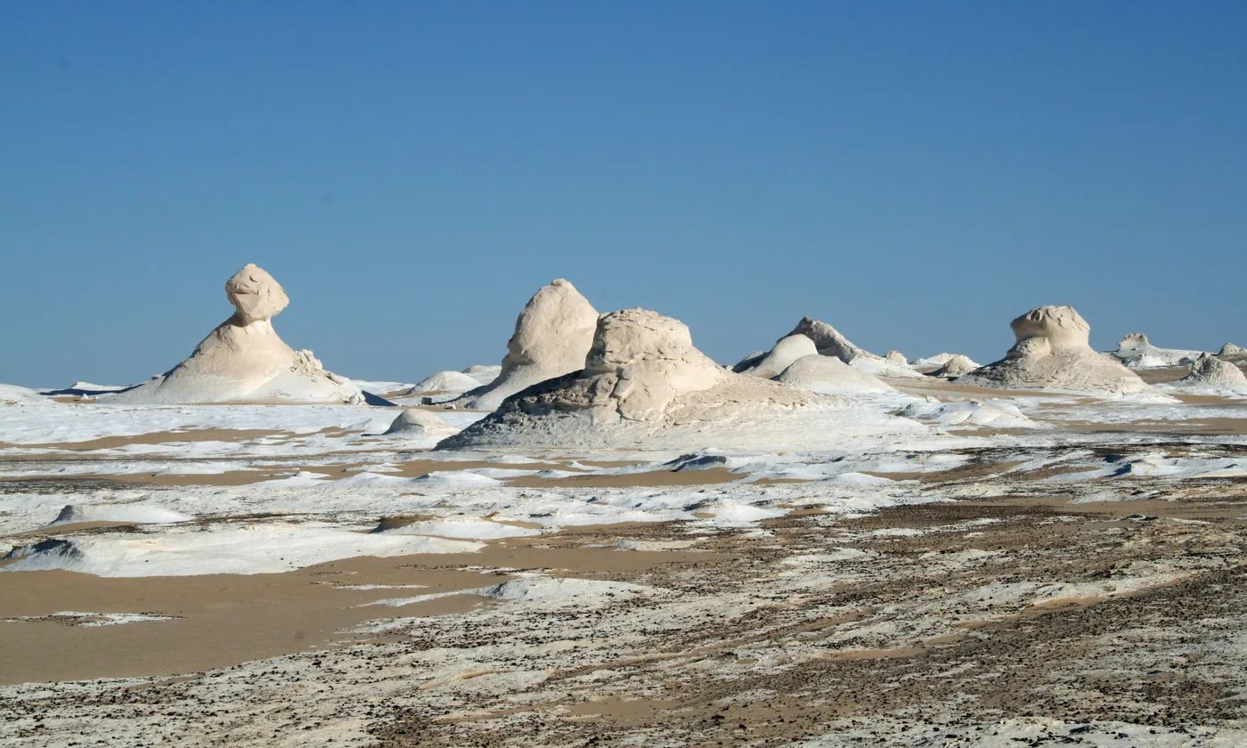 White chalk rock formations rising from the sand in the White Desert near Farafra